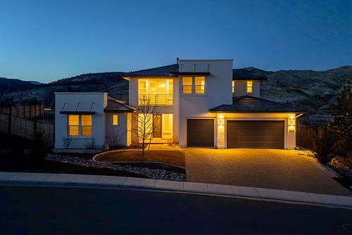 Modern two-story home lit up at twilight
